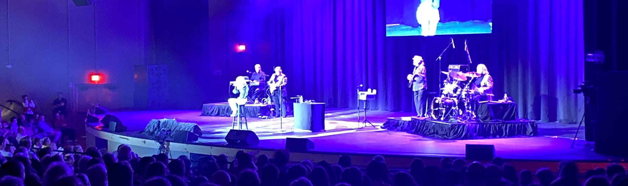 signer on stage in chair washed out by the lights San Jose